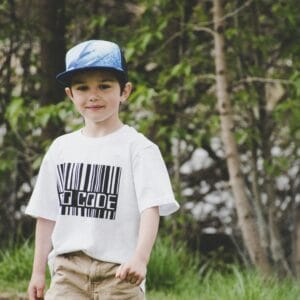 A cheerful young boy wearing a stylish t-shirt and cap, enjoying the outdoors.