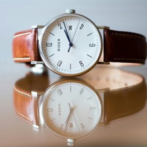 Close-up of a classic analog watch with leather strap and reflection.