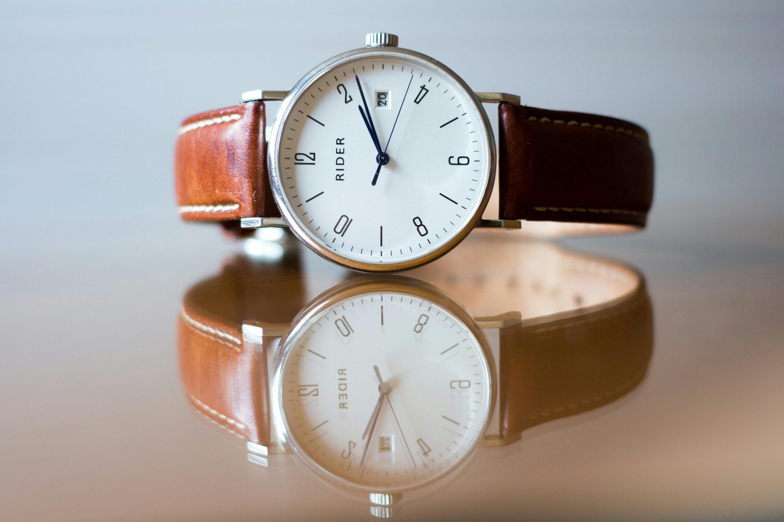 Close-up of a classic analog watch with leather strap and reflection.