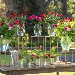 Beautiful outdoor floral arrangement with vibrant flowers on rustic table at a sunny event.